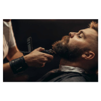 Fotografie Young bearded man getting beard haircut, zamrznutitonovi, 40 × 26.7 cm