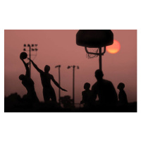 Fotografie Young men playing basketball at sunset., Grant Faint, 40x24.6 cm