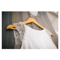 Fotografie Elegant wedding dress hanging on gray wall, JovanaT, 40 × 26.7 cm