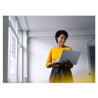 Fotografie Smiling woman using laptop, Westend61, 40 × 30 cm