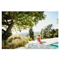 Fotografie Woman performing yoga on pool deck of home, Thomas Barwick, 40 × 26.7 cm