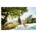 Fotografie Woman performing yoga on pool deck of home, Thomas Barwick, 40 × 26.7 cm