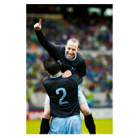 Umělecká fotografie Soccer player jumping into the arms of teammate, Thomas Barwick, (26.7 x 40 