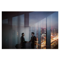 Fotografie Businessmen shaking hands in office at night, Shannon Fagan, 40 × 26.7 cm